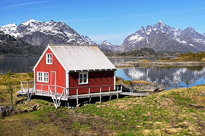 Norwegen, Nordland, Lofoten, Hütte am Raftsundet mit Blick zu den Bergen am Trollfjord