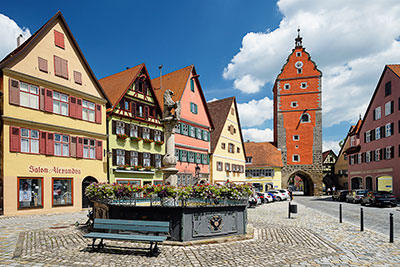 Deutschland, Bayern, Mittelfranken, Brunnen und historische Gebäude am Ledermarkt mit Wörnitztor im Hintergrund