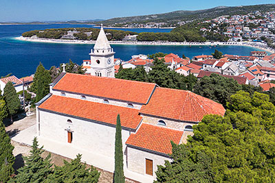 Kroatien, Sibenik-Knin, Dalmatien,Norddalmatien, St. Georgs Kirche auf dem höchsten Punkt der Altstadt mit dem Strand Mala Raduca im Hintergrund