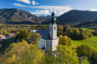 Deutschland, Bayern, Bayerische Alpen,Chiemgauer Alpen, Pfarrkirche St. Georg mit Rauschberg und Unternberg im Hintergrund